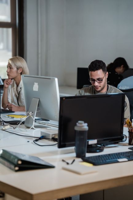 Zwei Geschäftsleute sitzen an einem Tisch mit Dokumenten und Laptop